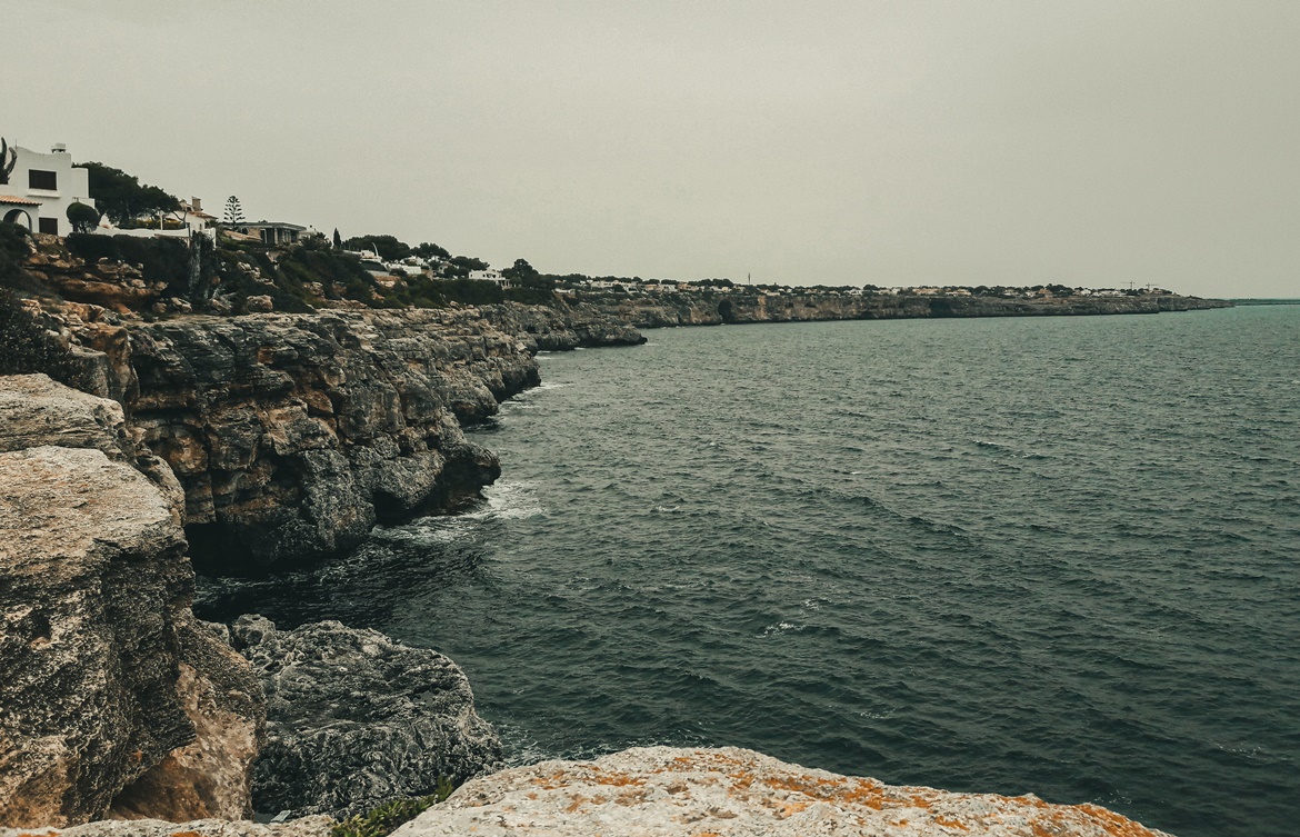 Cala Pi - widok na skaliste wybrzeże i pojedyncze domostwa